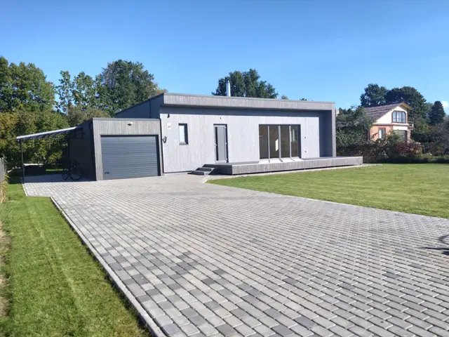 Gatava vienstāvu paneļu māja ar vertikālu dēļu fasādi